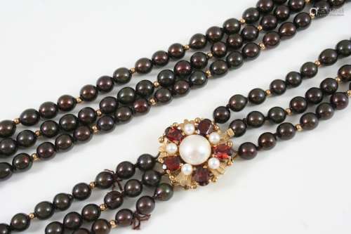 A THREE ROW UNIFORM CULTURED PEARL CHOKER the bronze coloured pearls are set to a garnet and