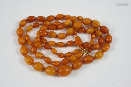 A SINGLE ROW GRADUATED AMBER BEAD NECKLACE 88cm. long, 27 grams.