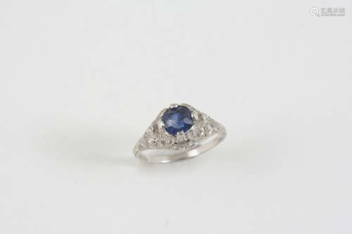 A SAPPHIRE AND DIAMOND RING the circular-cut sapphire is set within an ornate platinum mount set