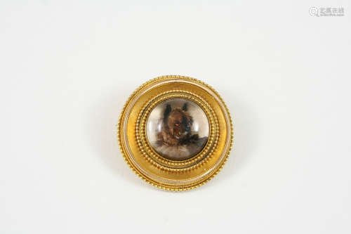 A REVERSE PAINTED CRYSTAL INTAGLIO BROOCH circular, depicting a cairn terrier, in a gold mount