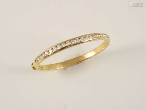 A DIAMOND AND GOLD HINGED BANGLE the 18ct. gold bangle is set with brilliant-cut diamonds to one