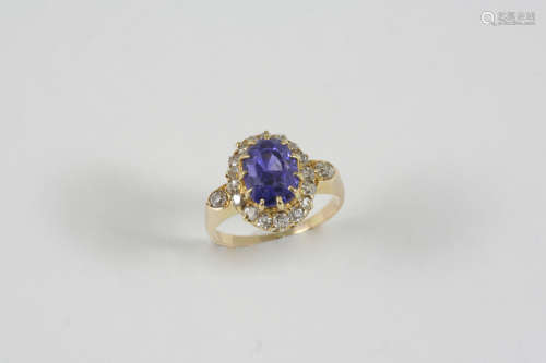 A TANZANITE AND DIAMOND CLUSTER RING the oval-shaped tanzanite is set within a surround of