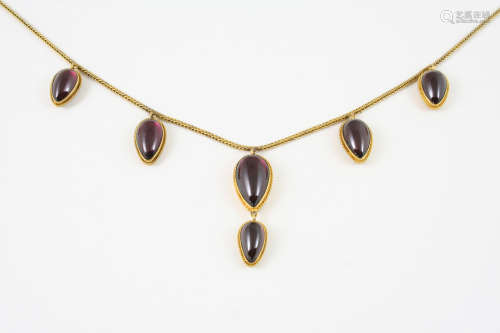 A VICTORIAN GARNET AND GOLD NECKLACE formed with graduated pear-shaped garnet drops, each backed