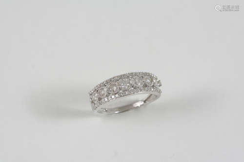 A DIAMOND RING set with a central row of graduated circular-cut diamonds within a border of