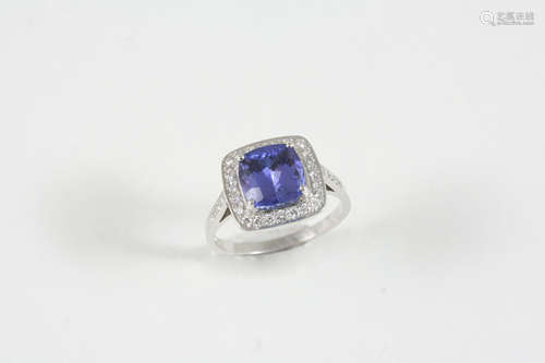 A TANZANITE AND DIAMOND CLUSTER RING the cushion-cut tanzanite is set within a surround of