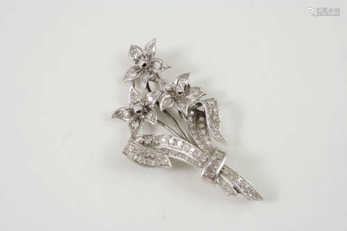 A DIAMOND FOLIATE SPRAY BROOCH set with four baguette-cut diamonds and overall with graduated