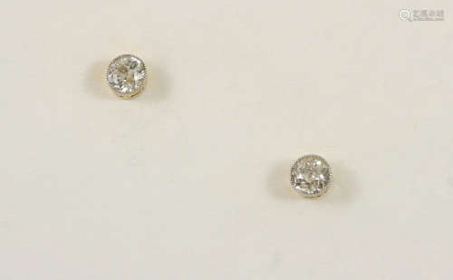 A PAIR OF DIAMOND STUD EARRINGS each set with a circular-cut diamond in a gold collet setting.
