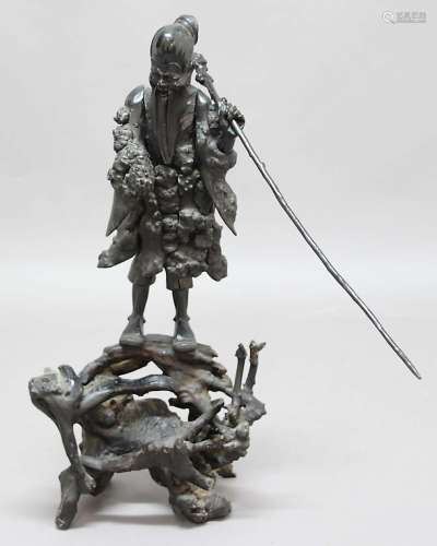 EBONISED ROOTWOOD CARVING, probably Japanese, of a sage holding his staff and a fruit, on a