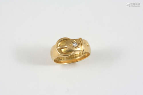 AN 18CT. GOLD BUCKLE RING set with a circular-cut diamond, 7 grams. Size P 1/2.