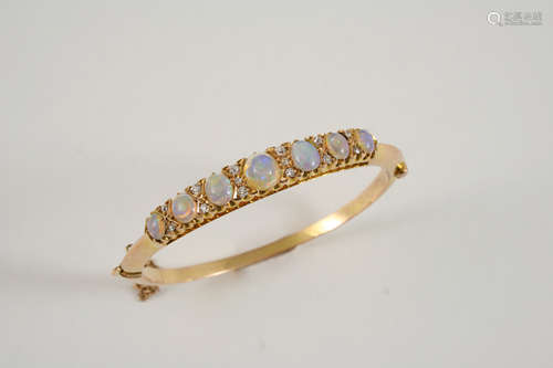 AN EARLY 20TH CENTURY OPAL AND DIAMOND HALF HINGED BANGLE set to one side with graduated oval