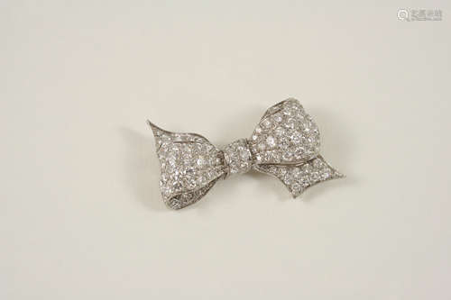 A DIAMOND BOW BROOCH millegrain set with graduated circular-cut diamonds, 4.5cm. wide.