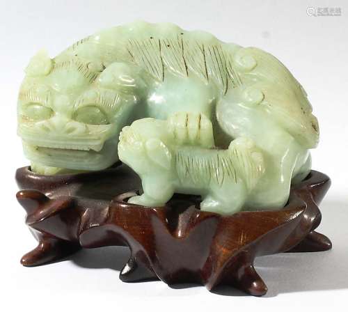 CHINESE CELADON NEPHRITE JADE FEMALE GUARDIAN LION, carved resting a paw on her puppy, on a hardwood