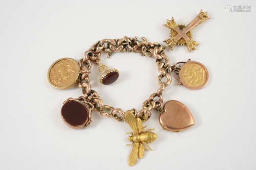 A GOLD CHARM BRACELET suspending various charms, including a gold half sovereign, 1914, in a 9ct.