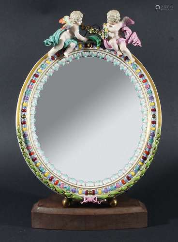 MEISSEN MIRROR, the oval plate in a frame with moulded 'jewels' and leaves, surmounted by a pair