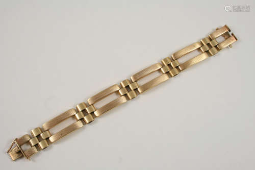 A 9CT. GOLD FANCY GATE LINK BRACELET with engine turned decoration to one side, and with concealed