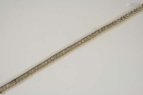 A DIAMOND LINE BRACELET set with fifty circular-cut diamonds, in gold, 18cm. long.
