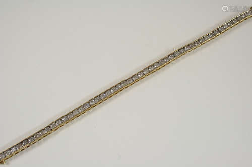 A DIAMOND LINE BRACELET set with fifty circular-cut diamonds, in gold, 18cm. long.