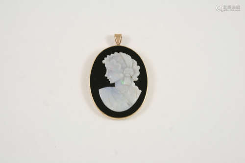A BLACK ONYX CARVED CAMEO PENDANT depicting the profile of a woman in classical clothing, mounted in