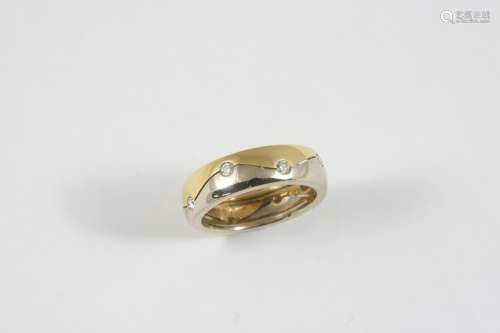 AN 18CT. TWO COLOUR GOLD BAND mounted with circular-cut diamonds. Size M 1/2.