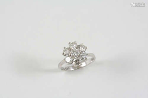 A DIAMOND CLUSTER RING the flowerhead design is set with seven circular-cut diamonds, in 18ct. white