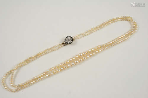 A DOUBLE ROW GRADUATED NATURAL PEARL NECKLACE the pearls graduate to a circular gold and black