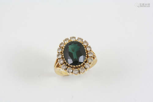 A DIAMOND AND GREEN STONE CLUSTER RING the oval-shaped green synthetic spinel is set within a