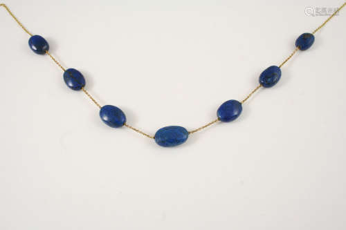 A GOLD AND LAPIS LAZULI BEAD NECKLACE the 9ct. gold chain is mounted with graduated oval-shaped