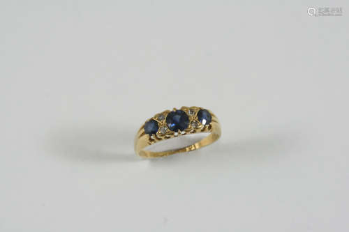 A SAPPHIRE AND DIAMOND RING the three graduated circular-cut sapphires are set with four small