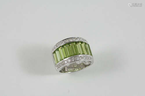 A PERIDOT AND DIAMOND RING the platinum band is centred with a row of baguette-shaped peridots