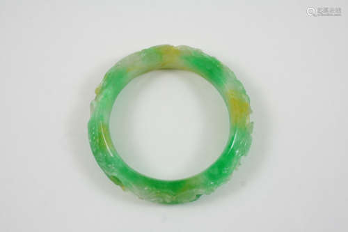 A CARVED JADE BANGLE with carved foliate decoration.
