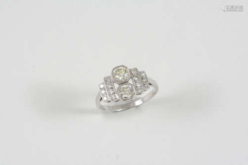A DIAMOND CLUSTER RING set with two circular-cut diamonds, with small circular-cut diamonds to