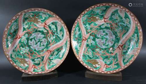 PAIR OF CHINESE FAMILLE VERTE CHARGERS, painted with a pair of scrolling dragons amongst clouds on a