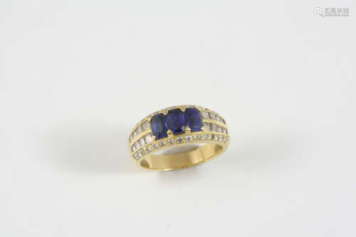 A SAPPHIRE AND DIAMOND RING the 18ct. gold band is centred with three octagonal-shaped sapphires,