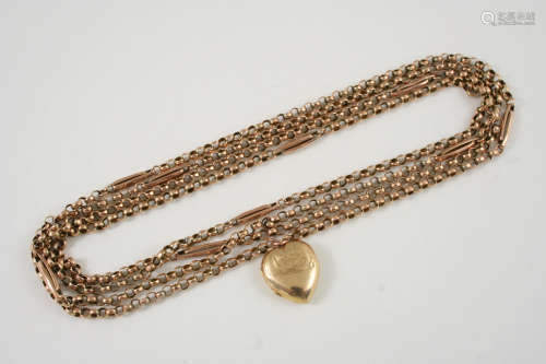 A 9CT. GOLD LONG GUARD CHAIN suspending a heart-shaped gold plated locket pendant, 146cm. long,