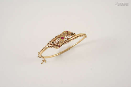 A RUBY AND DIAMOND HINGED BANGLE the gold openwork scrolling design bangle is set with three