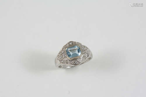 AN AQUAMARINE AND DIAMOND CLUSTER RING the step-cut aquamarine is set within a surround of small