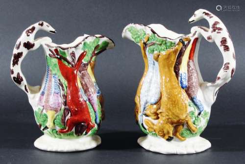TWO PEARLWARE GAME JUGS, mid 19th century, moulded with hanging game and hound handles, heights 19.