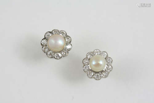 A PAIR OF DIAMOND AND PEARL CLUSTER STUD EARRINGS each untested pearl is set within a surround of