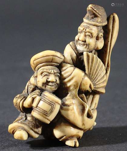 JAPANESE NETSUKE OF TWO IMMORTALS, one holding a fan the other a mallet, height 7cm