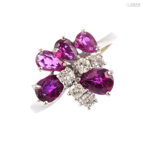 An 18ct gold ruby and diamond cluster ring. The brilliant-cut diamond chevron line, with graduated