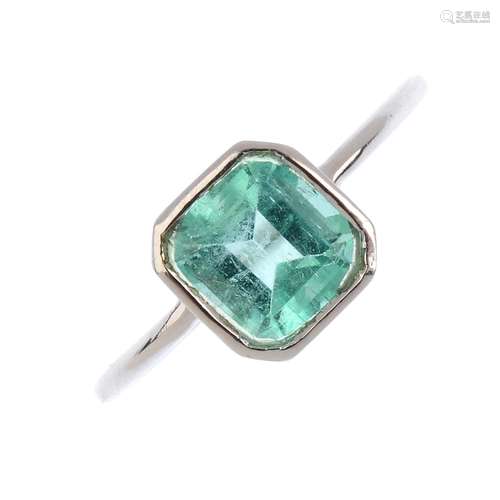 An emerald single-stone ring. The rectangular-shape emerald, with slightly tapered shoulders.