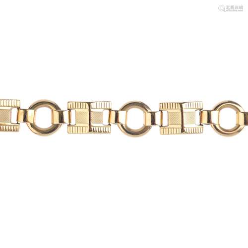 A 9ct gold bracelet. Designed as a series of textured pyramid-shape fancy links, with hoop spacers