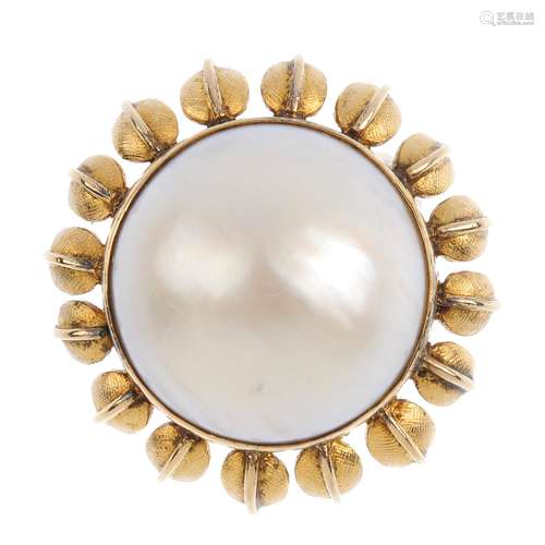 A mid 20th century 14ct gold mabe pearl floral ring. The mabe pearl, with textured petal surround.