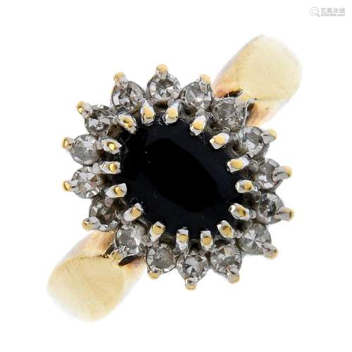 An 18ct gold sapphire and diamond cluster ring. The oval-shape sapphire, within a single-cut diamond