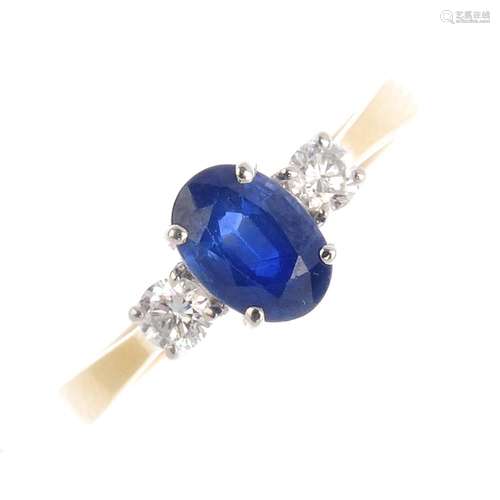 An 18ct gold sapphire and diamond three-stone ring. The oval-shape sapphire, with brilliant-cut