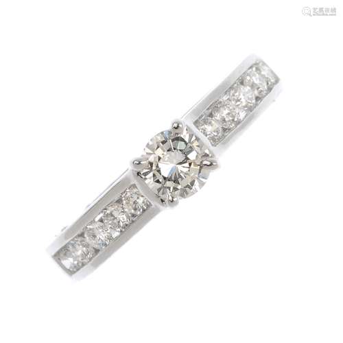 An 18ct gold diamond ring. The brilliant-cut diamond, with similarly-cut diamond shoulders.