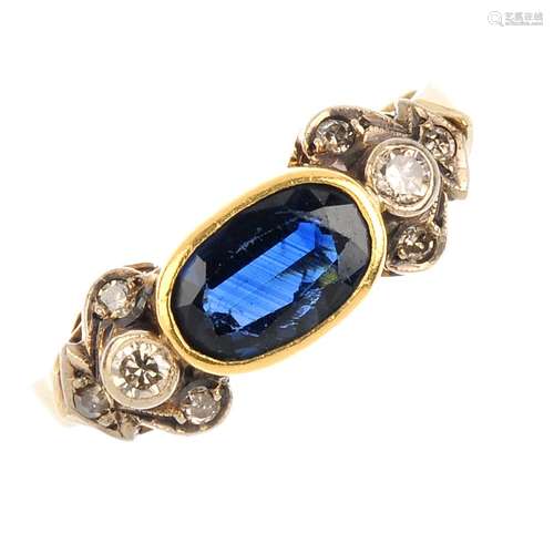 A sapphire and diamond ring. The oval-shape sapphire, with vari-cut diamond foliate shoulders.