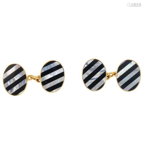 A pair of 9ct gold gem-set cufflinks. Each designed as two oval panels, with alternating onyx and