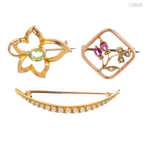 Three gem-set brooches. To include an early 20th century gold garnet and seed pearl floral brooch, a