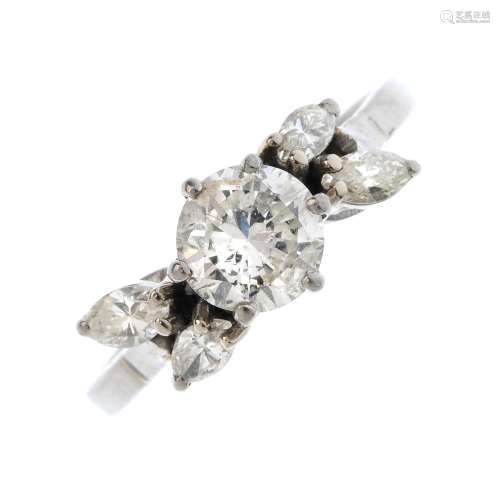 A diamond dress ring. The brilliant-cut diamond, with marquise-shape diamond asymmetric shoulders.